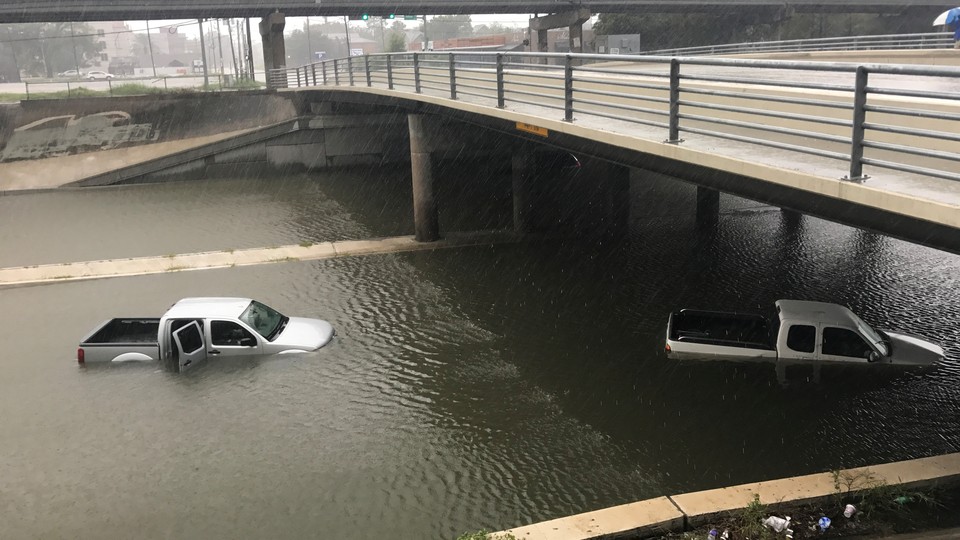 Trucks partially submerged on a flooded highway in Texas.