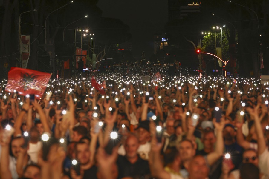 Hundreds of protesters hold up mobile phones during a rally.