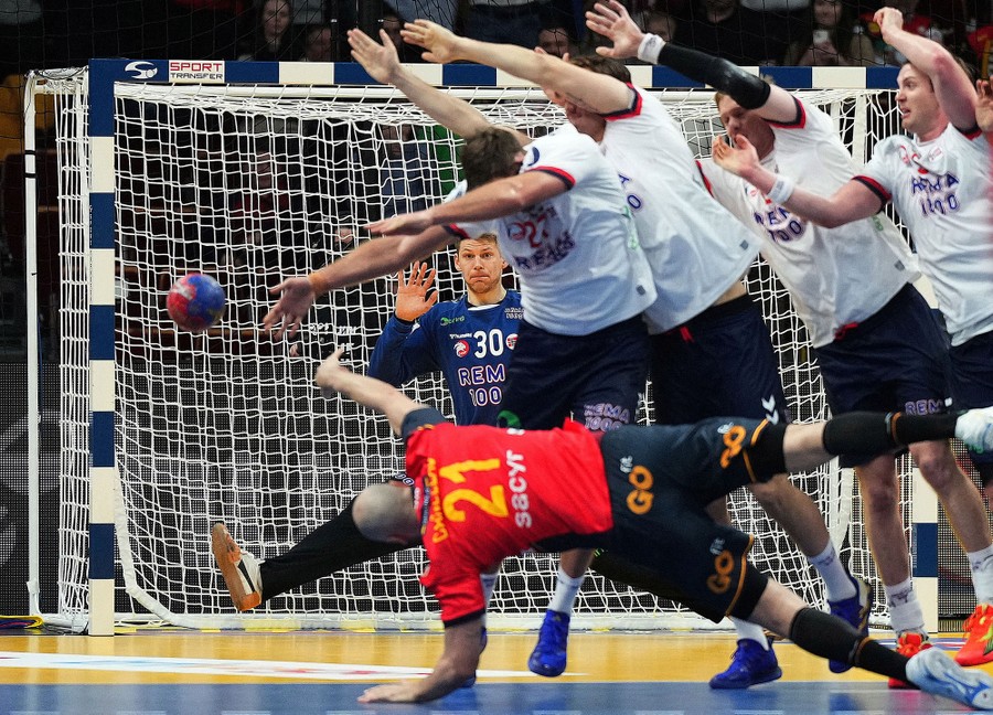 A player dives, trying to make a goal during a handball match.