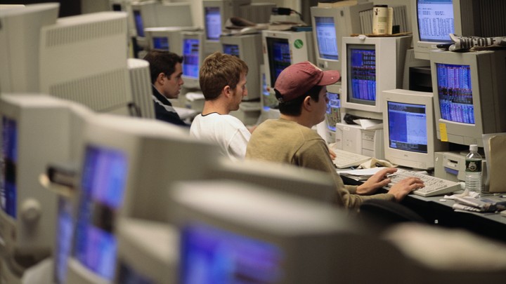 Three young men in a room full of computers