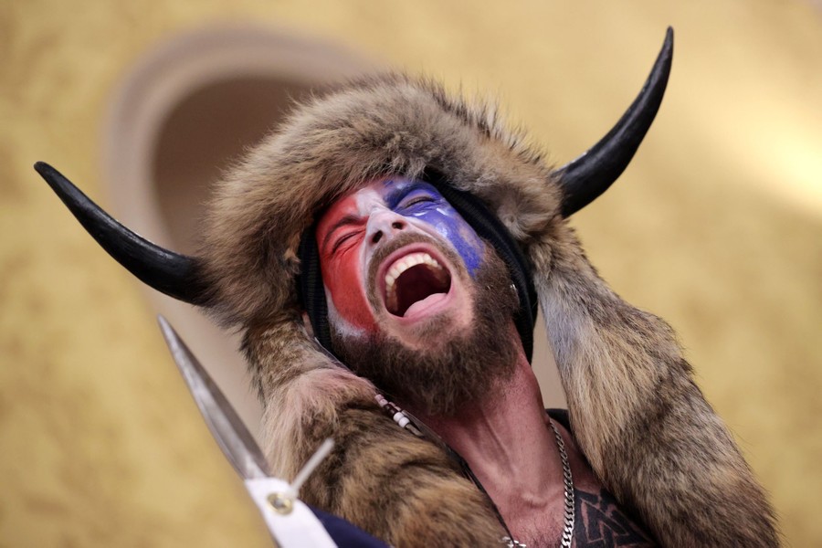 A man wearing a buffalo headdress yells inside the U.S. Capitol Building.