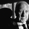 A black-and-white close-up photo of David McCullough from the shoulders up; he is wearing a suit and tie and smiling gently.