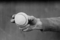 Black-and-white photo of a hand holding a baseball