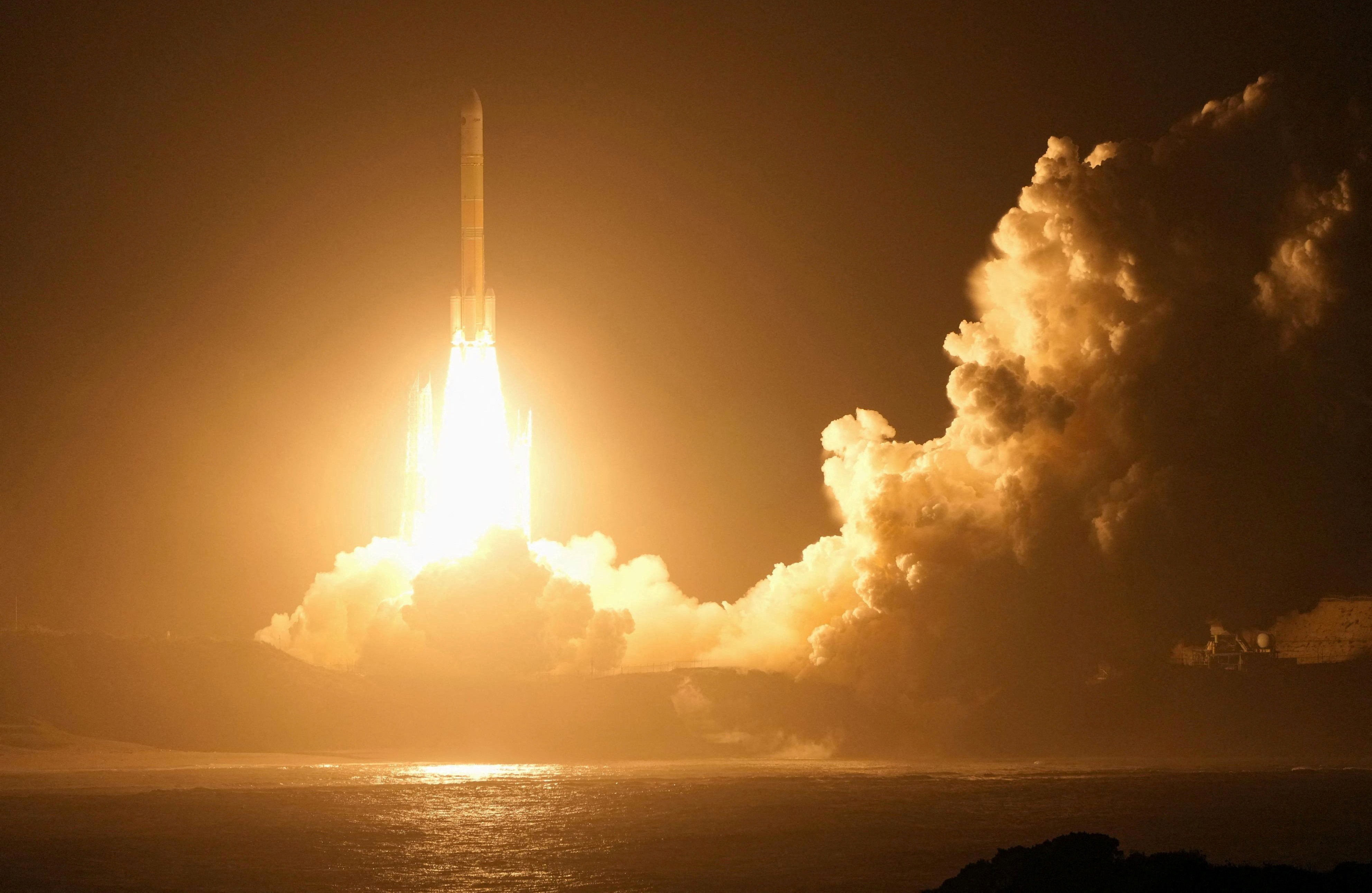 A rocket lifts off, seen at night.