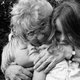 Black-and-white photo of a grandmother hugging two young children