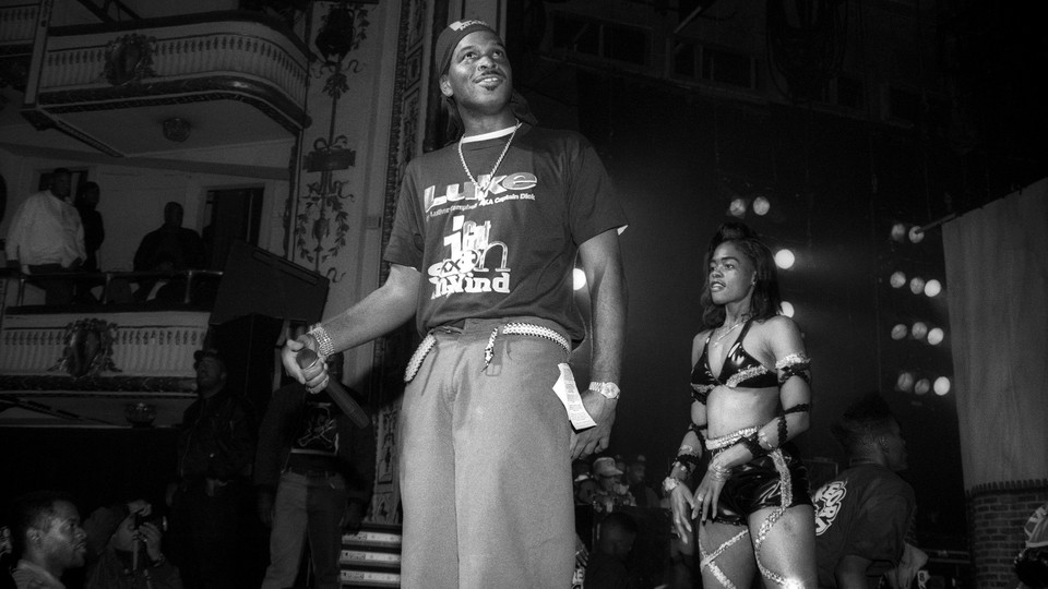 A black-and-white photo of the rapper Luther Campbell performing at the Apollo Theatre in New York City in 1992.