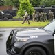 Law enforcement officers stage less than a mile from a shooting in Brooklyn Park, Minn.