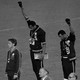 A black and white photograph of Tommie Smith and John Carlos raising their fists on the podium at the 1968 Olympics.
