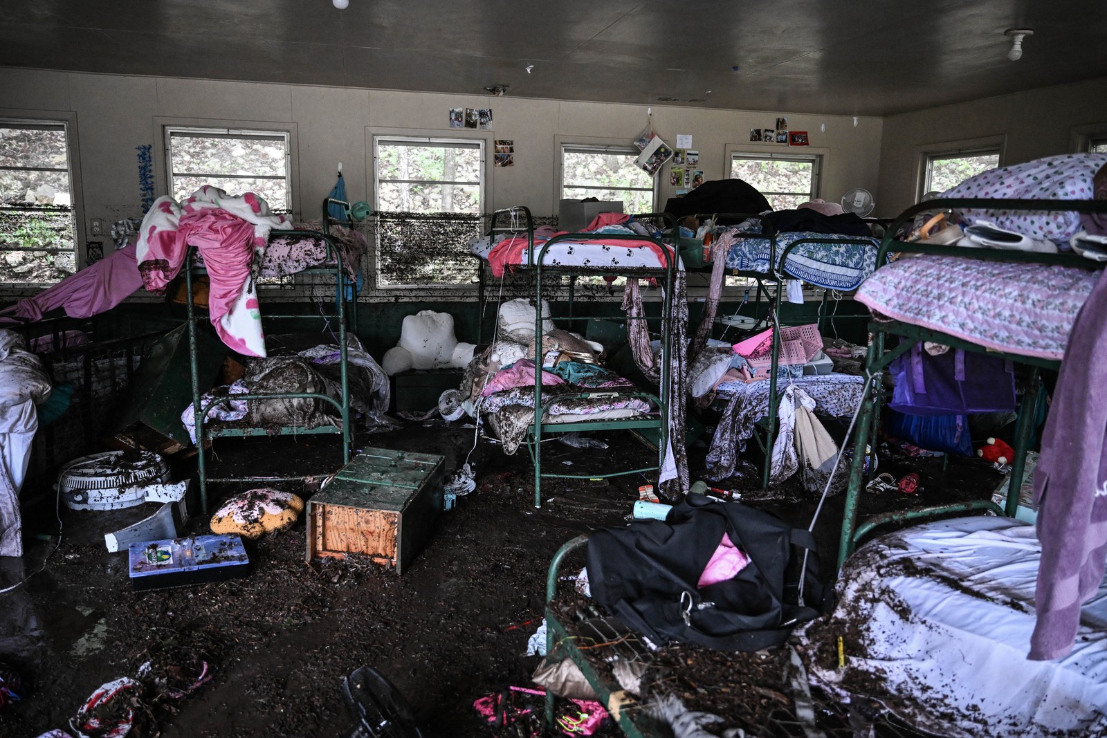 A view inside of a flood-damaged camp cabin with bunkbeds