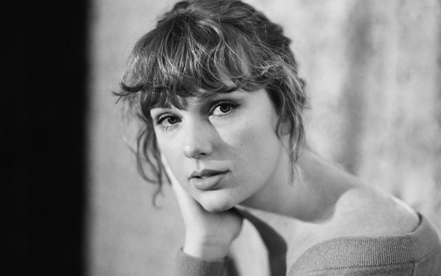 A black-and-white photo of Taylor Swift looking directly into the camera