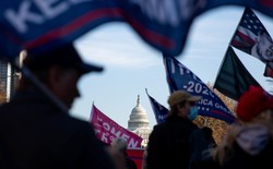 The U.S. Capitol is seen through a group of pro-Trump protesters waving flags on the streets of Washington, D.C.