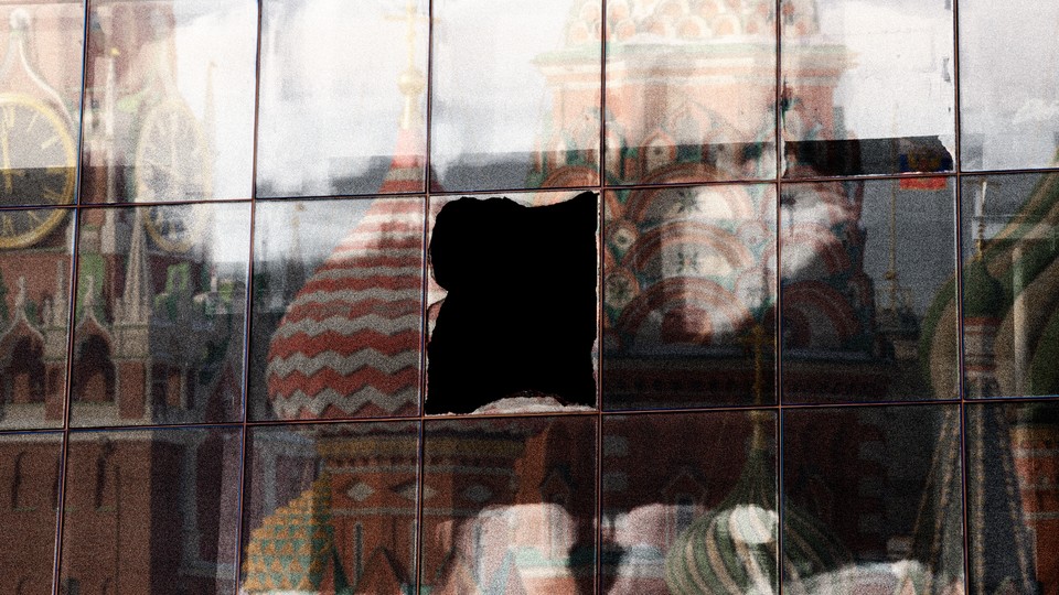 A broken window pane in building showing a reflection of the Kremlin.