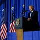 President Donald Trump delivers a speech in front of U.S. flags.
