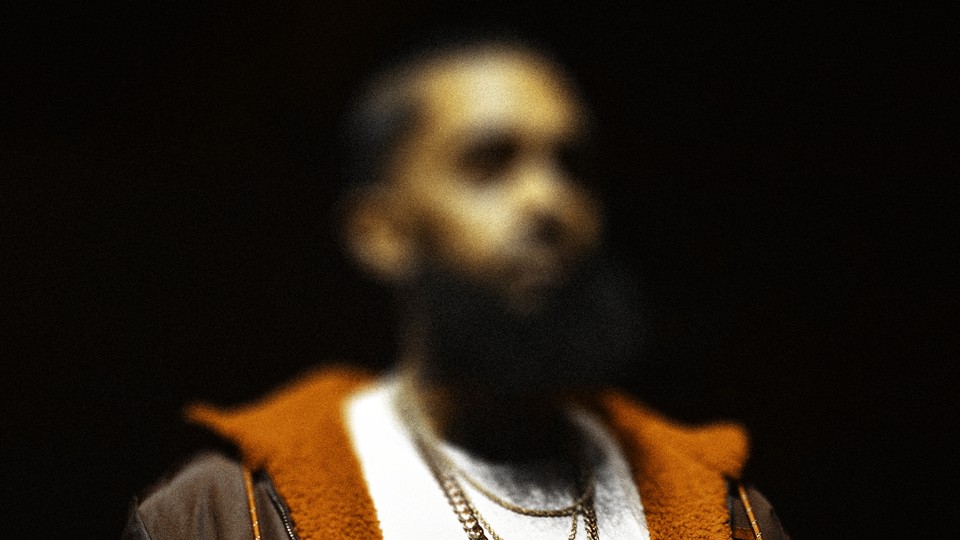 A picture of a young black man wearing chains and a hoodie but his face is blurred.