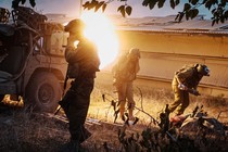 Soldiers take cover as they launch mortar rounds towards Gaza in southern part of Israel, Saturday, Oct. 14, 2023.