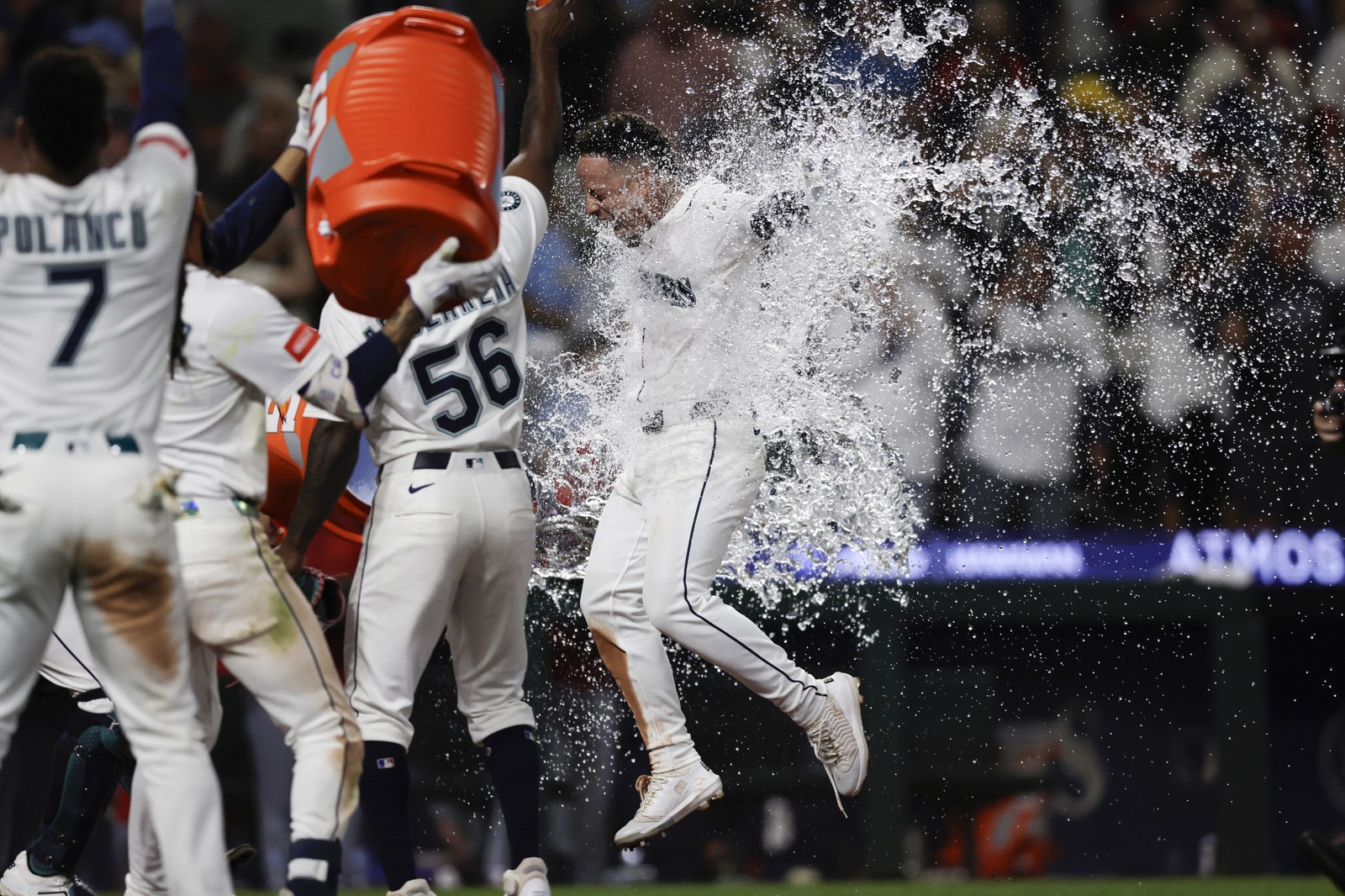 Baseball players dump a tub full of water onto a fellow player.