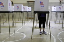 A woman votes in a voting booth at a school