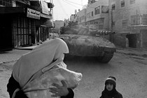 A woman and child in front of a tank