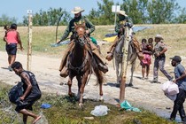 DHS agents with Haitian migrants at the border
