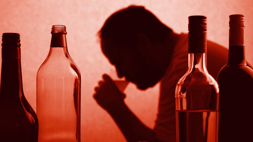 A silhouette of a man drinking from a cup next to bottles of wine and liquor