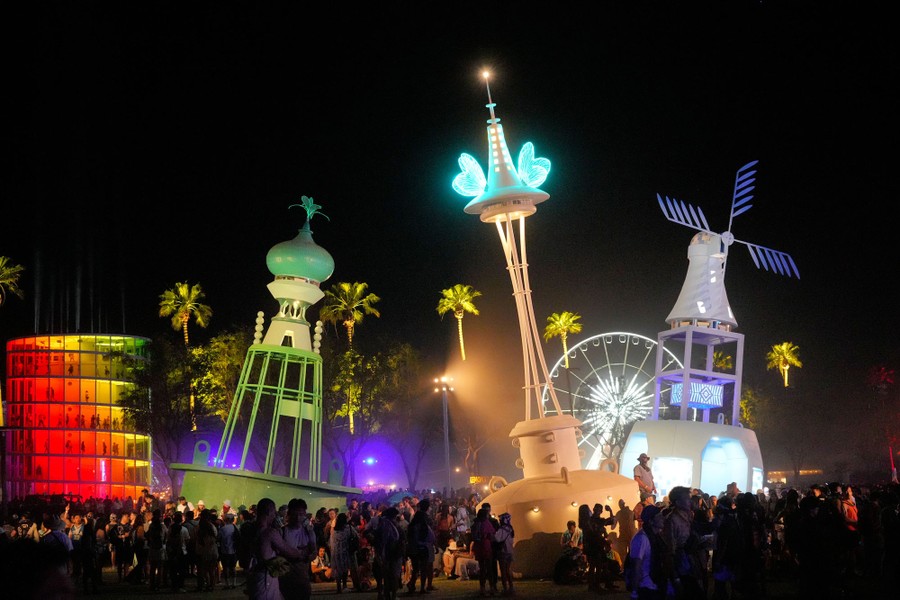 People gather around a large illuminated sculpture garden at night.