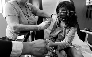 Bridgette Melo, 5, holds the hand of her father, Jim Melo, during her inoculation of one of two reduced 10 ug doses of the Pfizer BioNtech COVID-19 vaccine during a trial at Duke University in Durham, North Carolina September 28, 2021 in a still image from video. Video taken September 28, 2021.