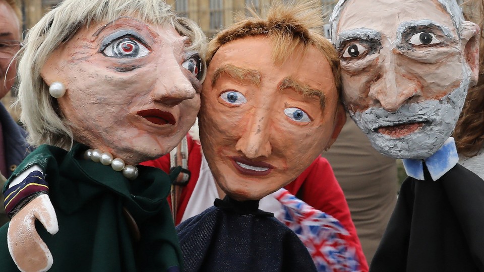 Performers pose Thursday with puppets of Prime Minister Theresa May, Tim Farron, leader of the Liberal Democrat Party, Jeremy Corbyn, leader of the Labour Party, in front of the Palace of Westminster in London.