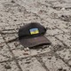 A cap with the Ukrainian flag and coat of arms on a city street