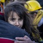 A child is carried by rescue workers.