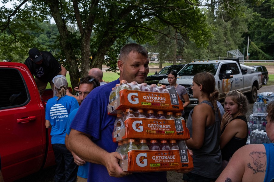 People carry food and drinks from the back of a pickup truck.