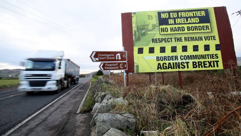 A truck crosses from the Republic of Ireland into Northern Ireland, past a sign that reads, "Border communities against Brexit."