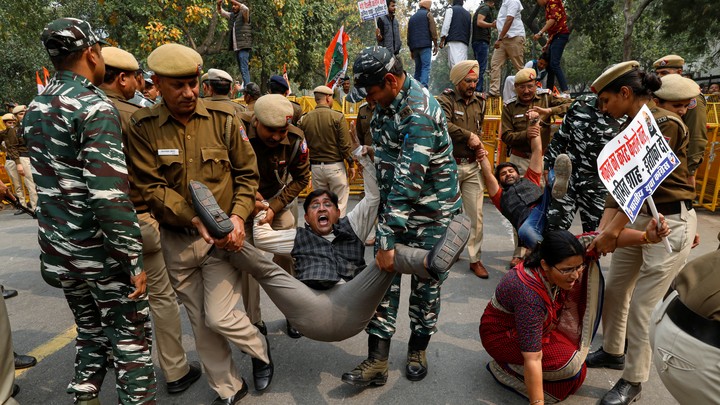 Police detain activists during a protest in Delhi.