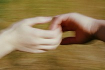 An interracial couple holds hands in a blurry image