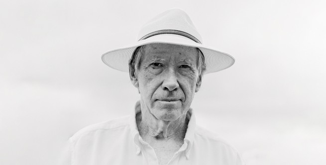 black and white photo of Ian McEwan wearing a straw fedora and a white collared shirt