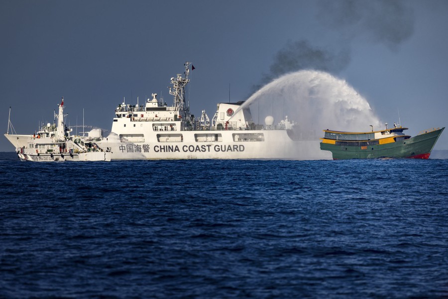 A Chinese Coast Guard ship fires a water cannon at a smaller ship.