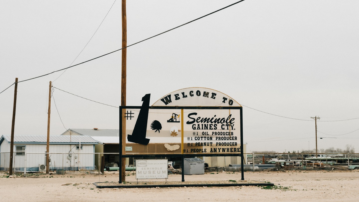 A welcome sign for Seminole Texas stands in a dirt lot