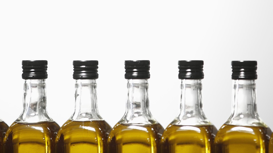 A close-up of bottles of olive oil against a white background