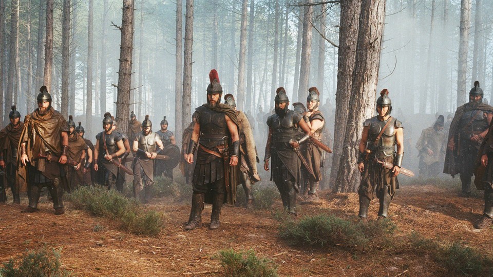 A group of men in Greek battle armor standing in the woods