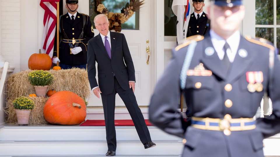 Joe Biden stands on one leg in front of the White House.
