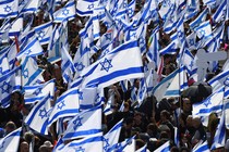 A crowd of protesters waving hundreds of Israeli flags.