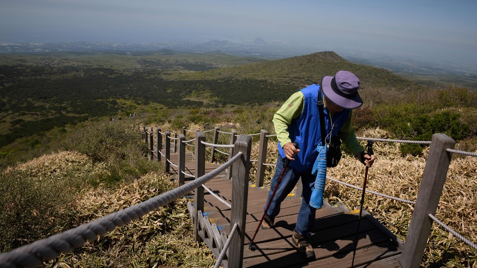 A hiker ascends stairs on a mountain in South Korea.