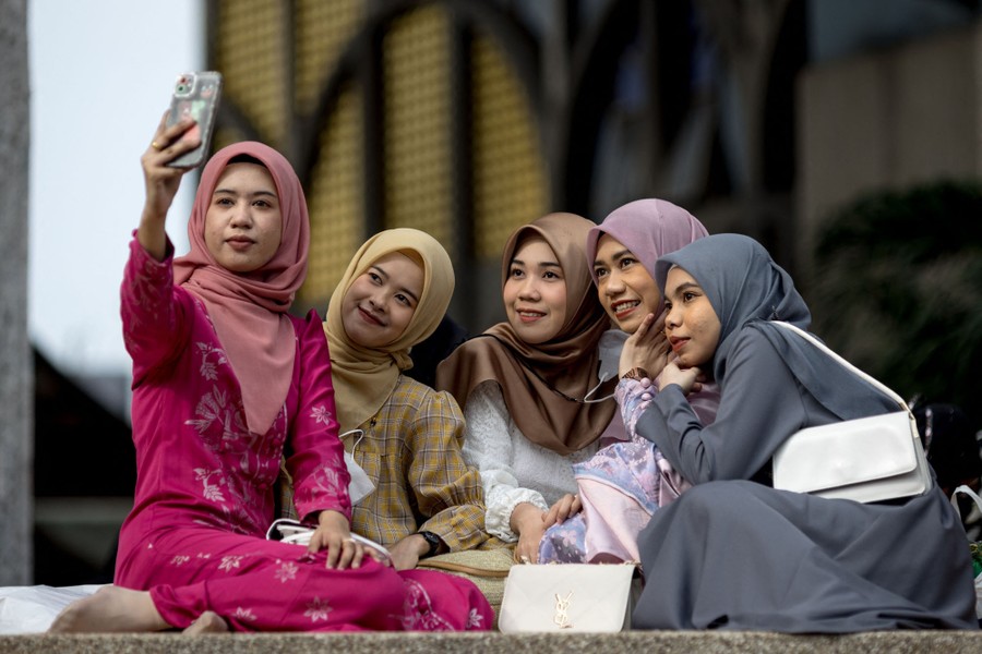 A group of five young women take a photograph of themselves.