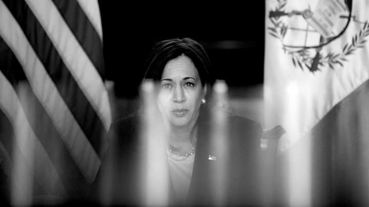 A back-and-white photo of Kamala Harris framed by American and Guatemalan flags behind her