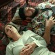 Yusra and Mo lay down on the floor together, their heads on two pillows.