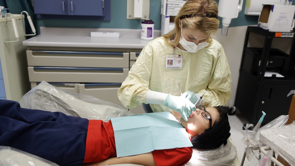 A female dentist treats a patient