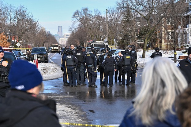 Police officers and bystanders at the scene of a shooting in Minneapolis