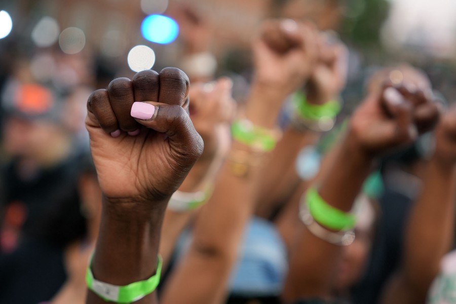 A close view of the upraised fists of a group of Harris supporters