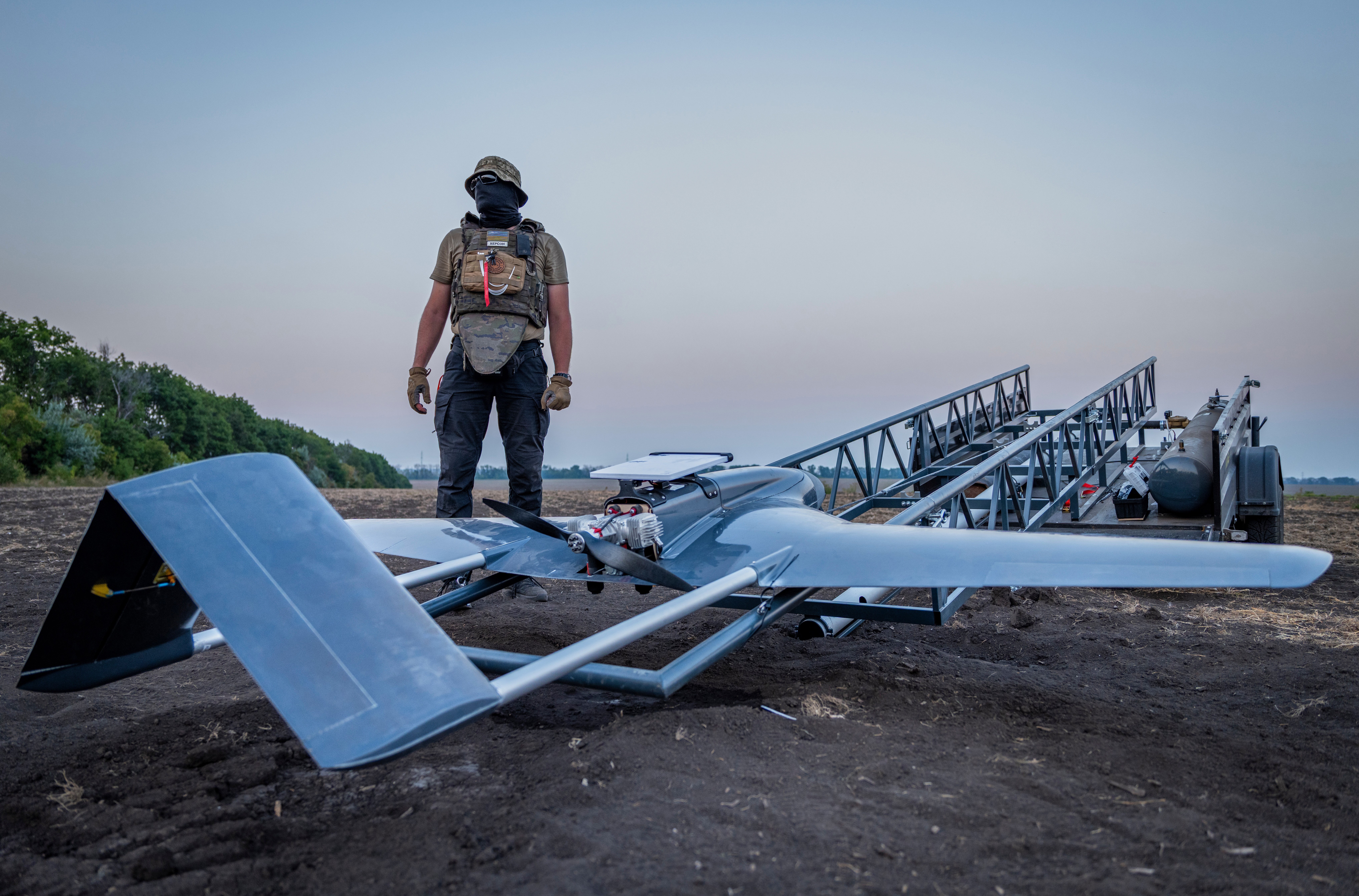 A Ukrainian serviceman prepares a fixed-wing strike drone for launch.