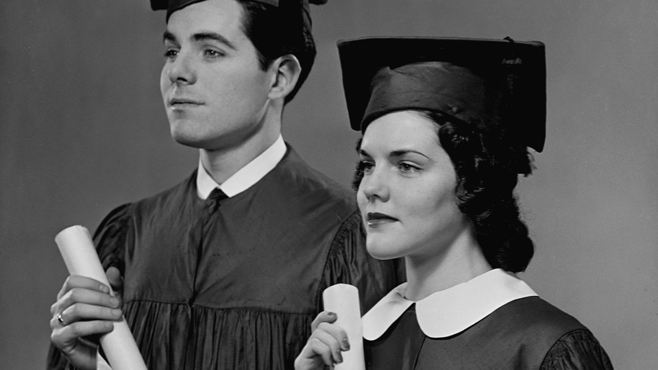 A man and a woman hold college diplomas
