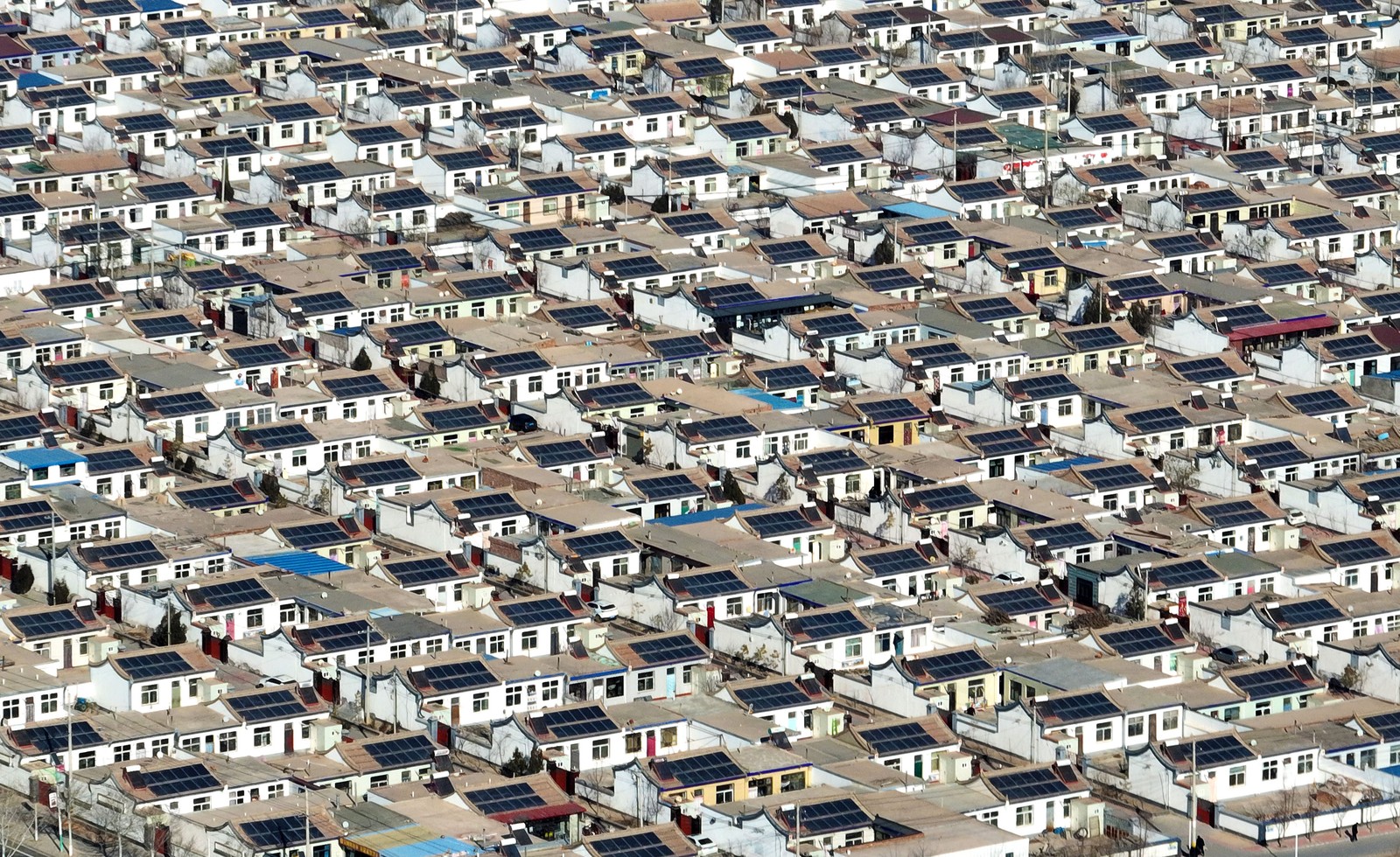 Photovoltaic panels cover the roofs of many houses in a residential development.